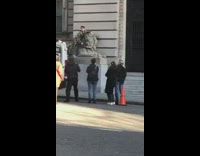 Guy poses with lion statue 