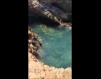 Man shirtless slipped on the beach rock
