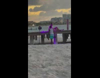 Woman in bikini sits on the docks with lighting equipment