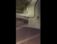 Man hold football beside black car street