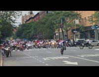 Guy on motorcycle does wheelie on street 