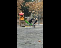 Two men video shoot spin roundabout playground