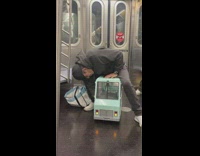 Man sits on toy blue truck on subway 