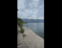 Woman brown top with a cap video selfie near the river