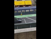 Guy wearing yellow pants kicks ball down street
