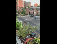Guy red ATV wheelie on street