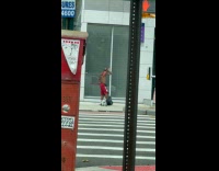Man with devil props dances on sidewalk
