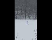 man in white jump suit walking alone through snow