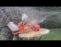 Guy cut coke bottles with chainsaw slow motion