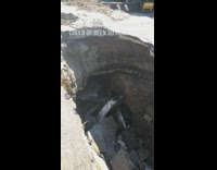 Big sinkhole in the middle of street, broken concrete