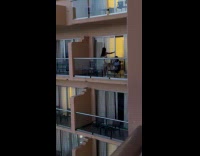 Woman tube top poses at the balcony