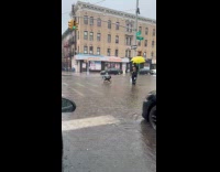 Man use broom to clear manhole during flood