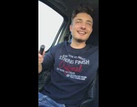 Blue sweater guy in car drops object 