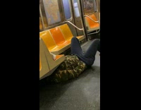 Guy lays on floor underneath subway seat 