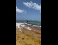 Guy on wakeboard with parachute jumps over ocean