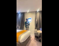 Man looks at small window in hotel room