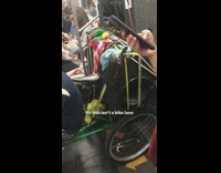 Man rides bike with speakers and cargo wagon onto subway train