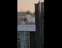 Girl sit rooftop building string light night