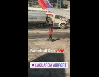 Airplane worker does a baseball swing with his traffic safety baton