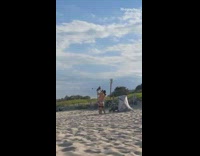 Parents lift baby windy beach beanie trolley