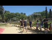 Guy jumps on red green yellow jumper with two friends and does a front flip