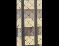 Two women dance window opposite building