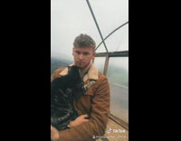 Brown jacket guy holds cat rain 