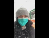 Girl walks down sidewalk during snowstorm guy 