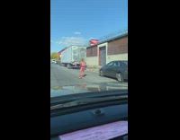 Woman in all red rolling down street in roller skates 