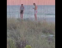 Black shorts girl dances beach pink sky 