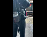 Woman has cup of water with no lid on bag