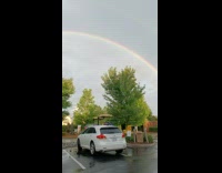 Rainbow full arc seen on the cloudy sky