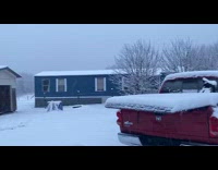 Snowfall covers the whole house and cars in the yard