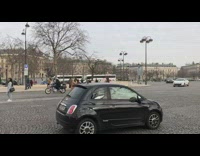 Woman takes picture in front of Arc de Triomphe