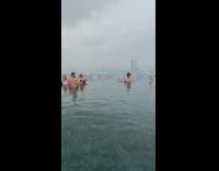Man spiked hat swim infinity pool cityscape