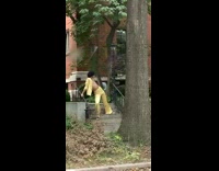 Man in yellow disco outfit poses at the park stairs