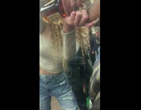 Woman with sunglasses pressures girl to take a shot of hennessey on subway train