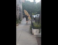 Man walk on street carry his surfboard