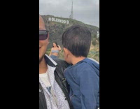 Kid carried by father and stares at woman poses behind