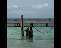 Woman bikini cling pole hammock beach windy