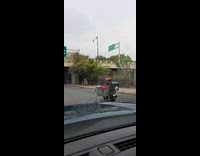 Men rides motorcycle while dragging shopping cart