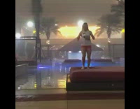 Girl bounces ball on knees by pool 