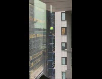 Man in green climbing scaffolding of a building