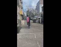 Guy rides bike with tv on head 