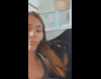 Large black brown dog licks face girl