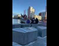 Man in white shirt handstand on the ladder rails at the river