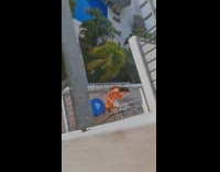 Woman orange dress vlog  tripod neighbor balcony 