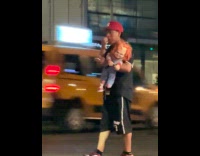 Man cross the street carry chucky doll