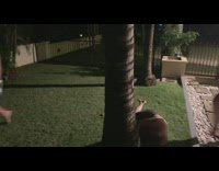 Two guys boxing on a lawn and one knocks the other out