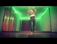 Guy dances inside room with mirror and colorful lights 